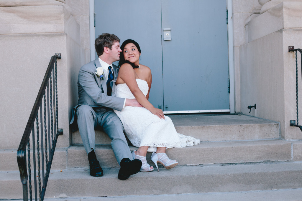 Bride and Groom sitting on steps outside reception in Masonic Ballroom in Eau Claire, Wisconsin
