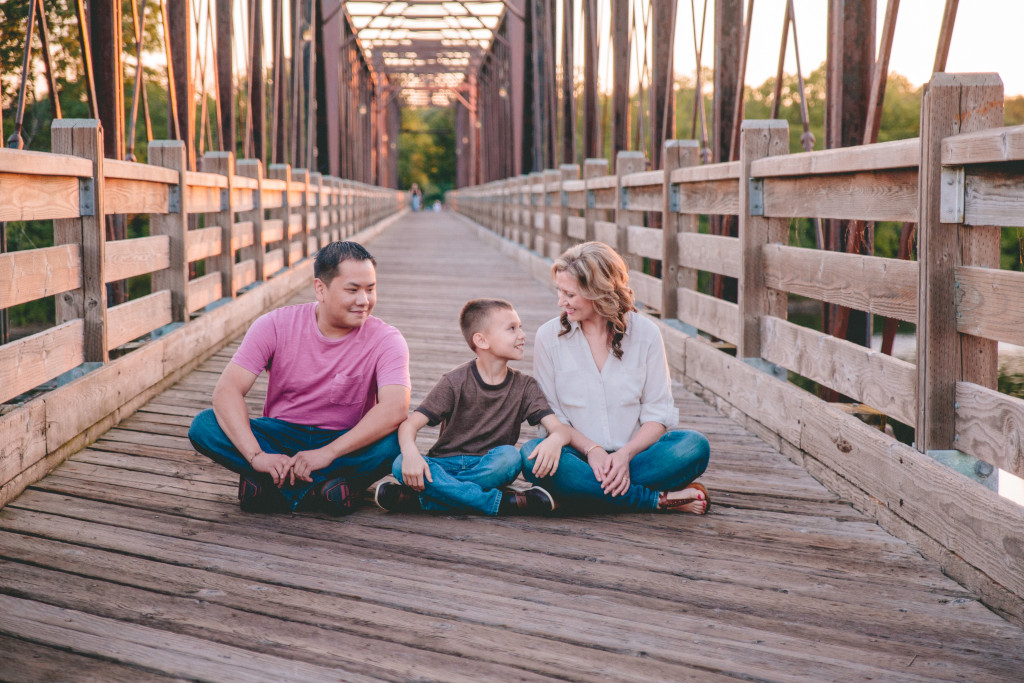 family posed at walking bridge in eau claire's phoenix park
