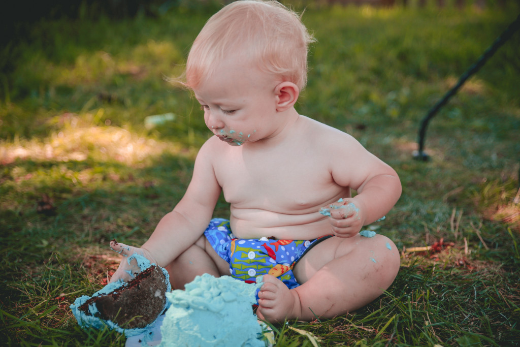 little boy loving his blue smash cake