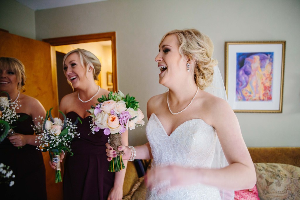 Bride laughing with her bridesmaids before the cereomny by Alisha Marie Eau Claire Wedding Photographer