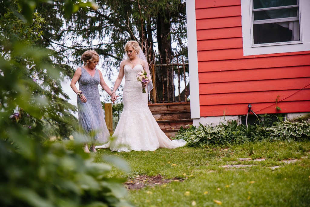 Bride being excorted down the aisle by her mother during the processional photo by Alisha Marie Eau Claire Wedding Photographer