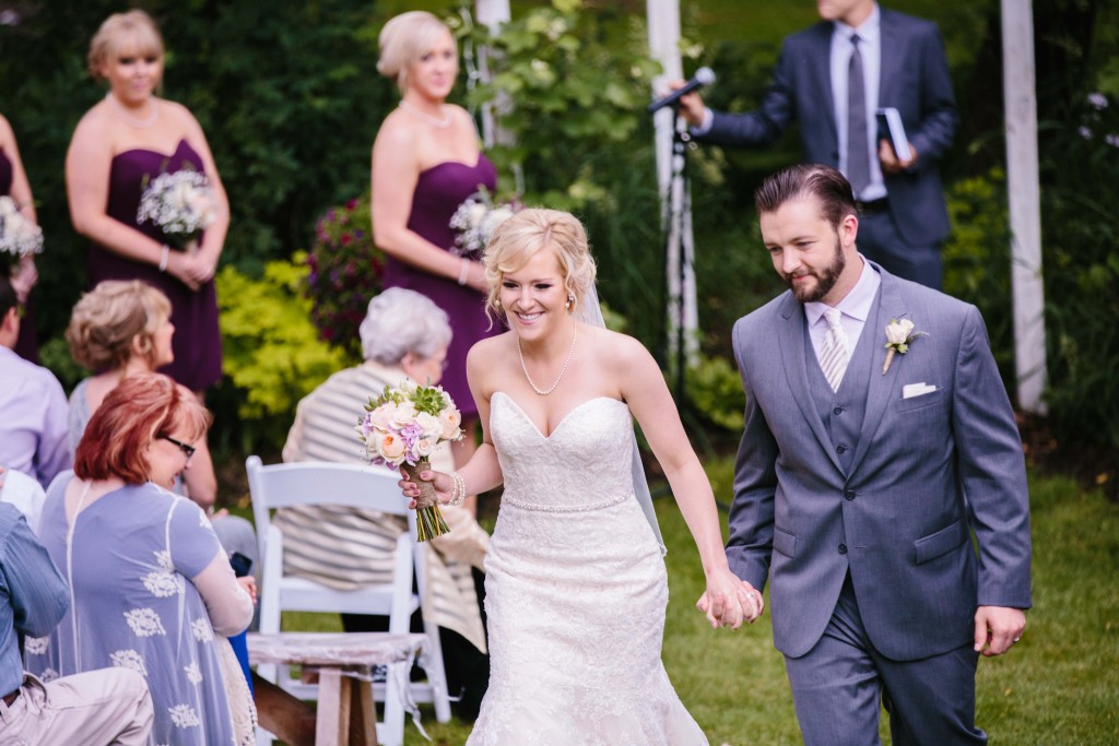Happy bride and groom walking down the aisle photo by Alisha Marie Eau Claire Wedding Photographer