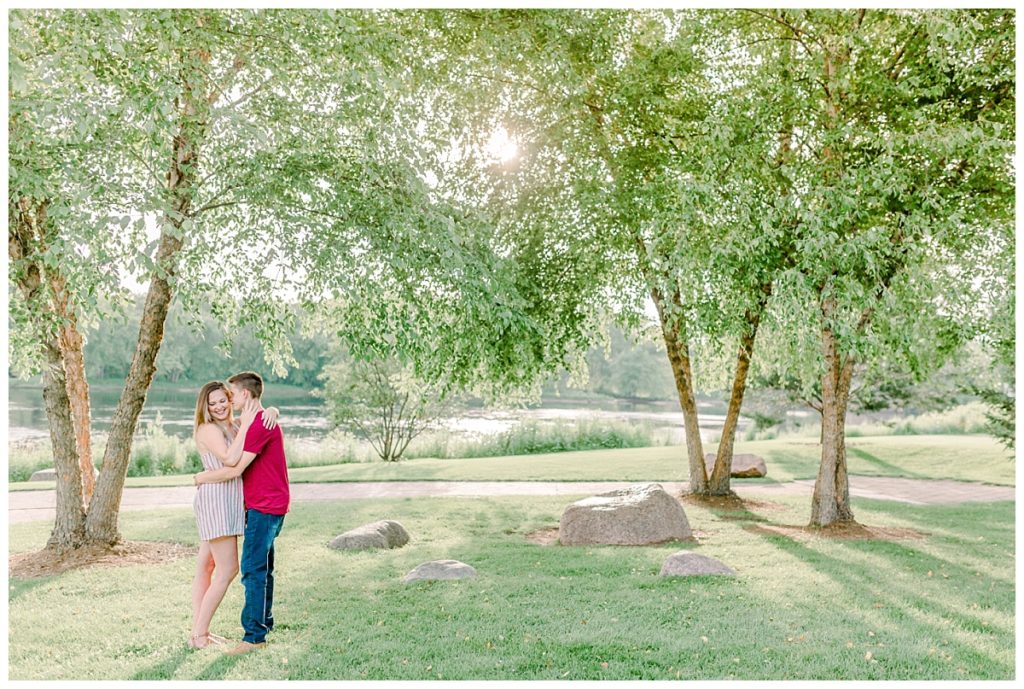 downtown Eau Claire wisconsin engagement session  images taken at phoenix park  pulled back image with the sun coming through the trees