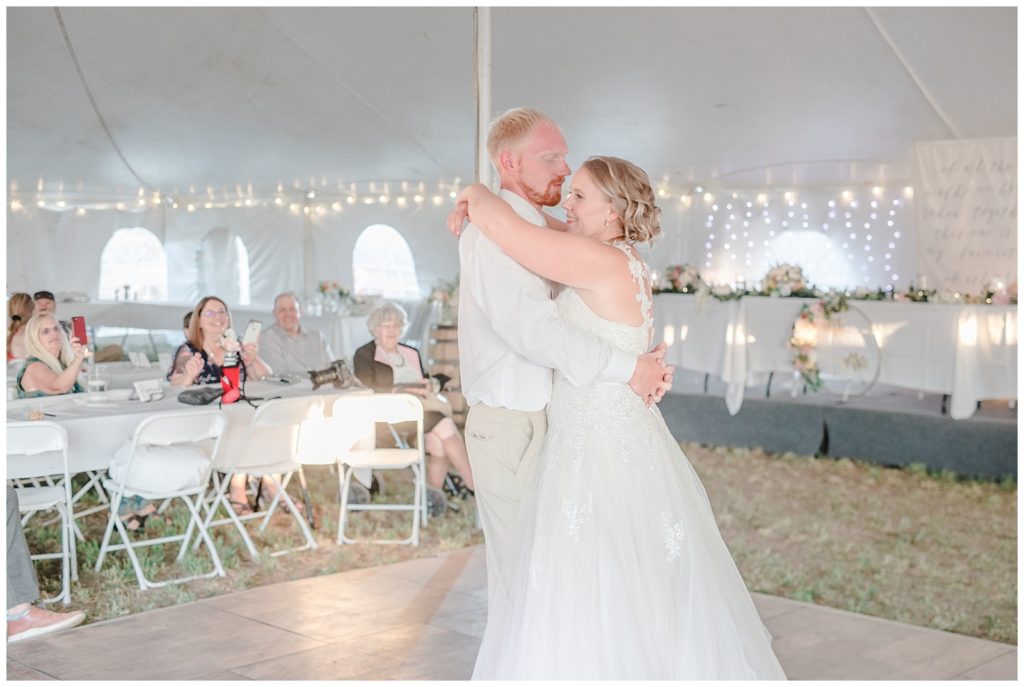 Bride and groom doing their first dance in a tent wedding in their back yard. Eau Claire Wisconsin