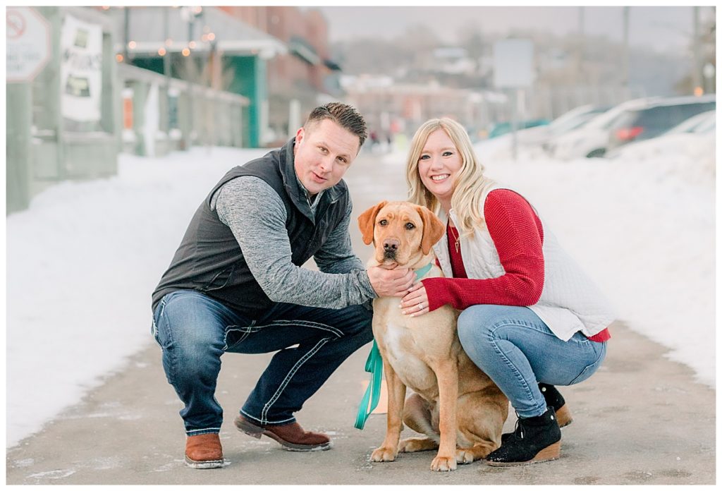 Downtown Stillwater Engagement Photos taken by Alisha Marie Photography out of Eau Claire wi. Couple poses with their beautiful dog in the winter for their portraits