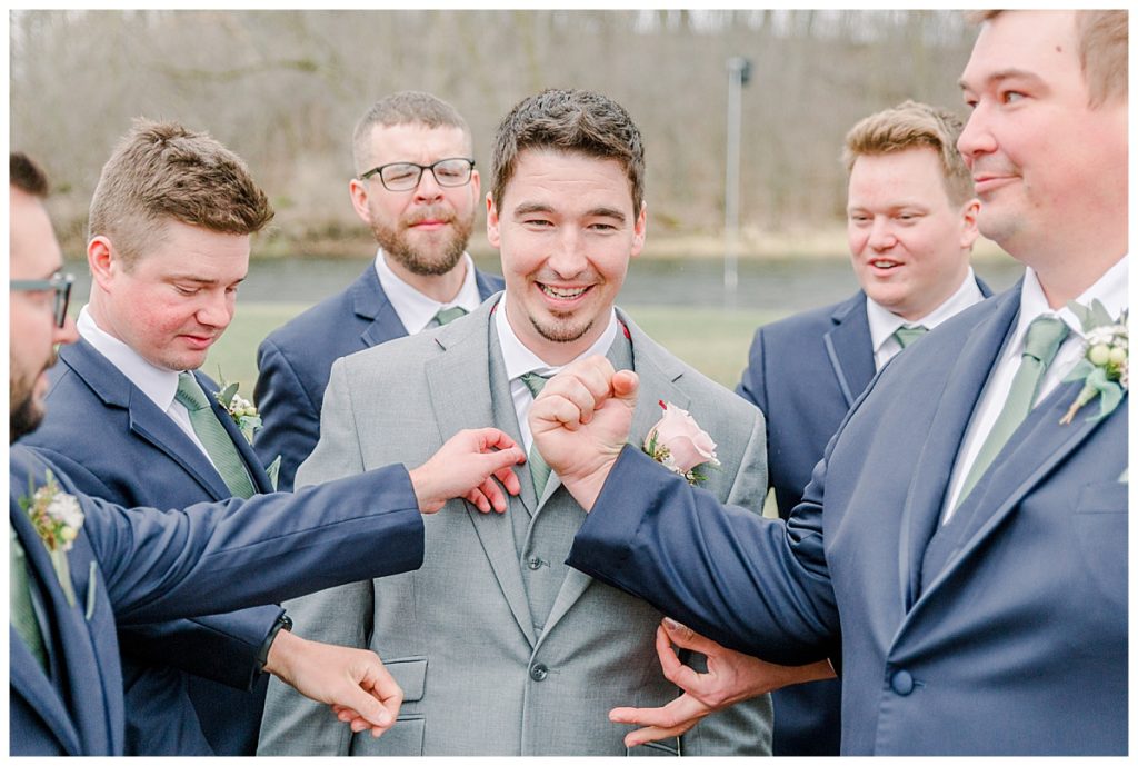 Taken by Wisconsin wedding photographer Alisha Marie Photography, specializes in Eau Claire wedding photographer, family photos Eau Claire wedding dress shop and image portrait in wisconsin and Stillwater minnesota rainy day wi wedding photographer wedding party portraits groomsmen goofing around