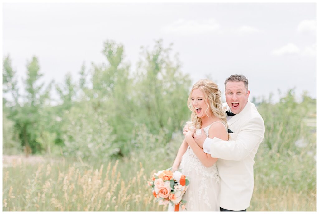 bride and groom laughing together while posing for photography outside their Minnesota wedding venue