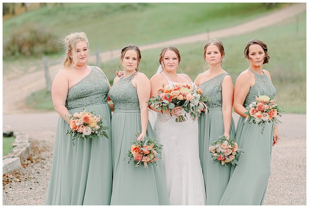 Wedding day wedding party portrait.Bridesmaids are laughing together. The women and bridesmaids wear a light green. Image by Alisha Marie Photography at the wedding venue alluring acres not far from Minneapolis, Minnesota and St. Paul