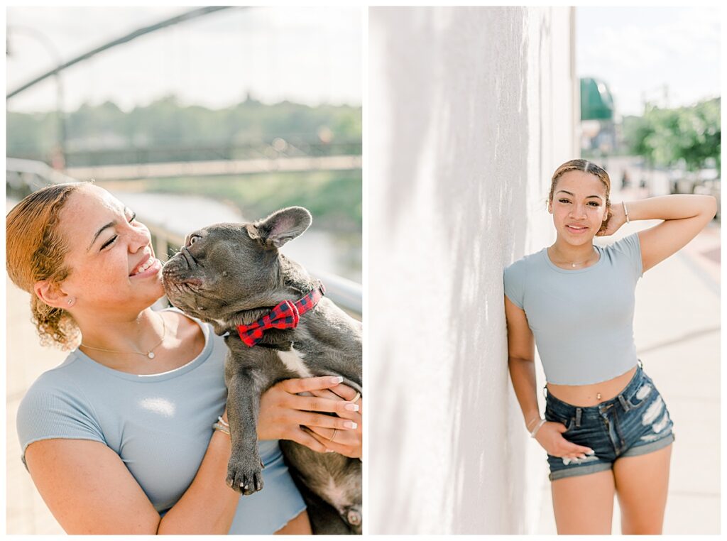 Downtown Eau Claire Senior Portraits taken at on Barstow street in Wisconsin with a white wall behind the senior in her portraits she poses with her adorable French bulldog