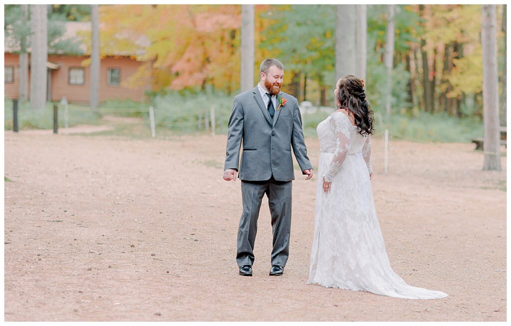 Lake Wissota Fall wedding photography taken by Alisha Marie Photography First Look on their wedding day, groom looks thrilled to see his gorgeous bride in her lace dress