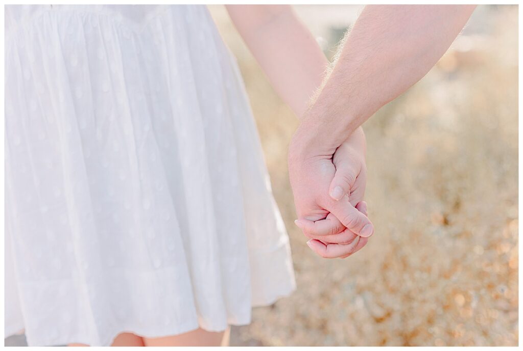 Couple holds hands in the desert at Usery Mountain Regional Park near Tempe Arizona.