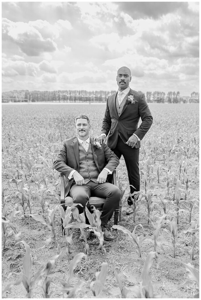 beautiful black and white image of two grooms standing in a corn field in mondovi and eau claire wisocnisn | Photography by Alisha Marie Photography